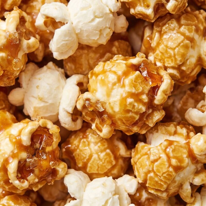 Close-up of caramel popcorn clusters with glossy caramel coating, sweet crunchy gourmet snack